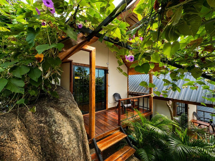 Bungalow entrance surrounded by flowers and rocks