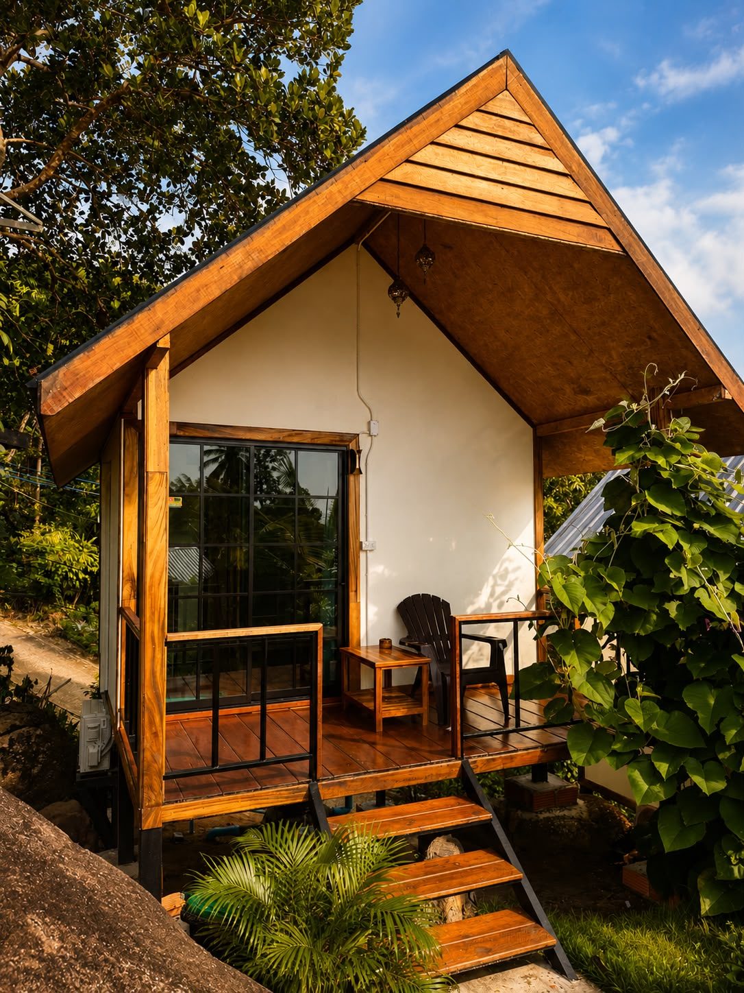 Wooden bungalow with a terrace among tropical plants